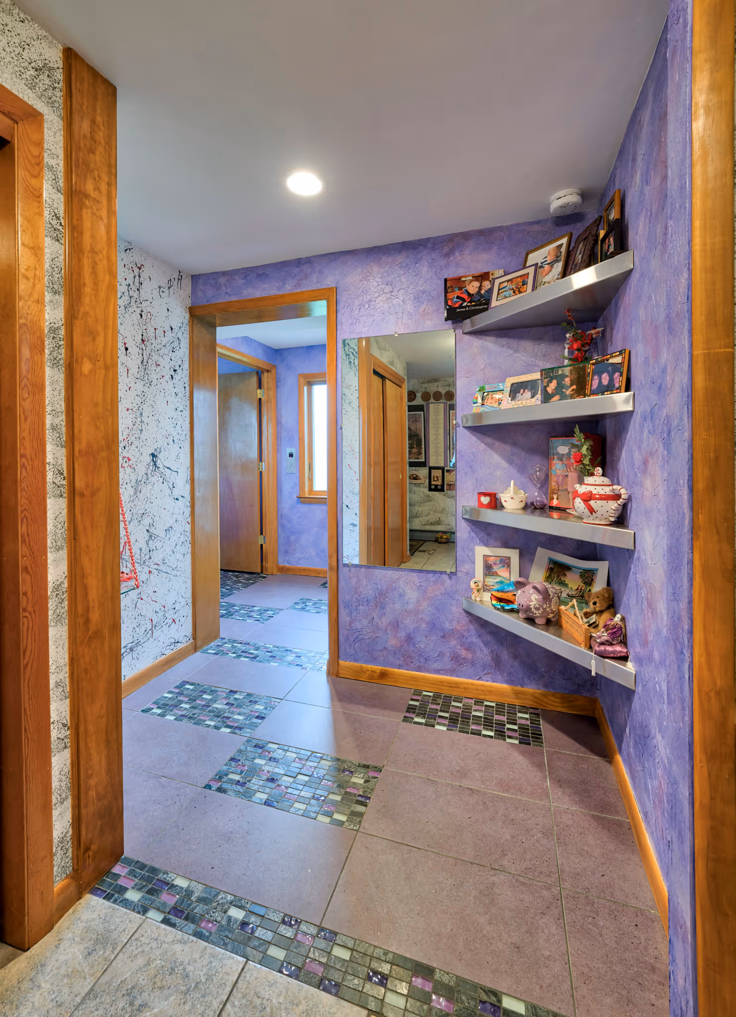 Colorful hallway with purple walls, unique tile flooring, and decorative shelves in Camp Hill, PA