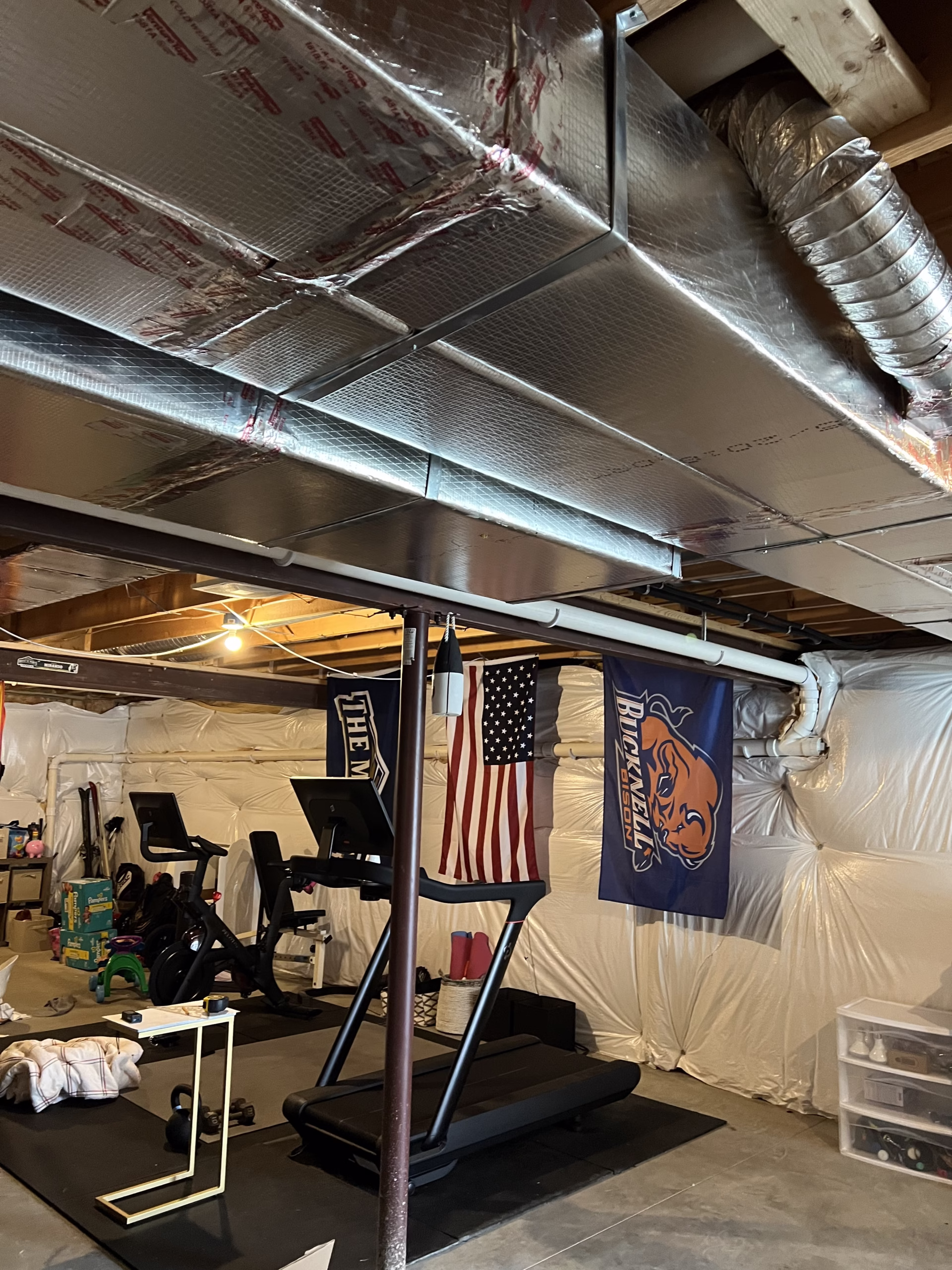 Home gym in Mechanicsburg, PA featuring exercise equipment, wall flags, and insulated ceiling.