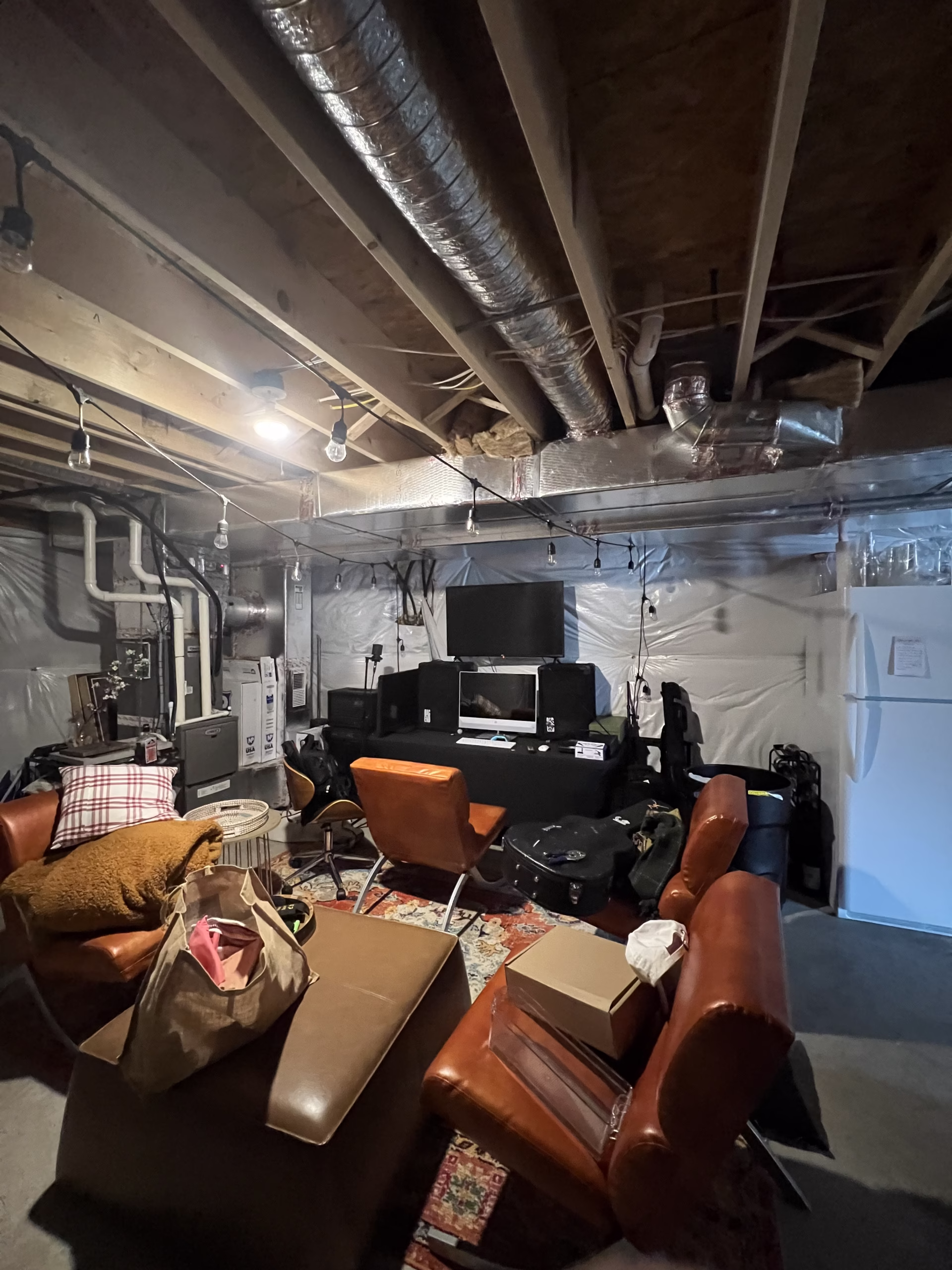 Cozy basement lounge in Mechanicsburg, PA with leather chairs, a patterned rug, and modern decor.