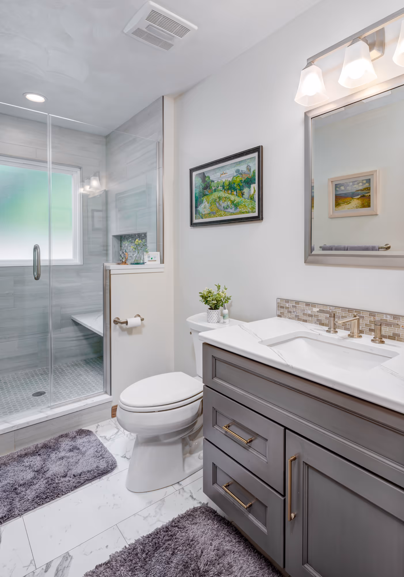 Modern bathroom in gettysburg, pa featuring a gray vanity, marble countertop, and glass shower enclosure.