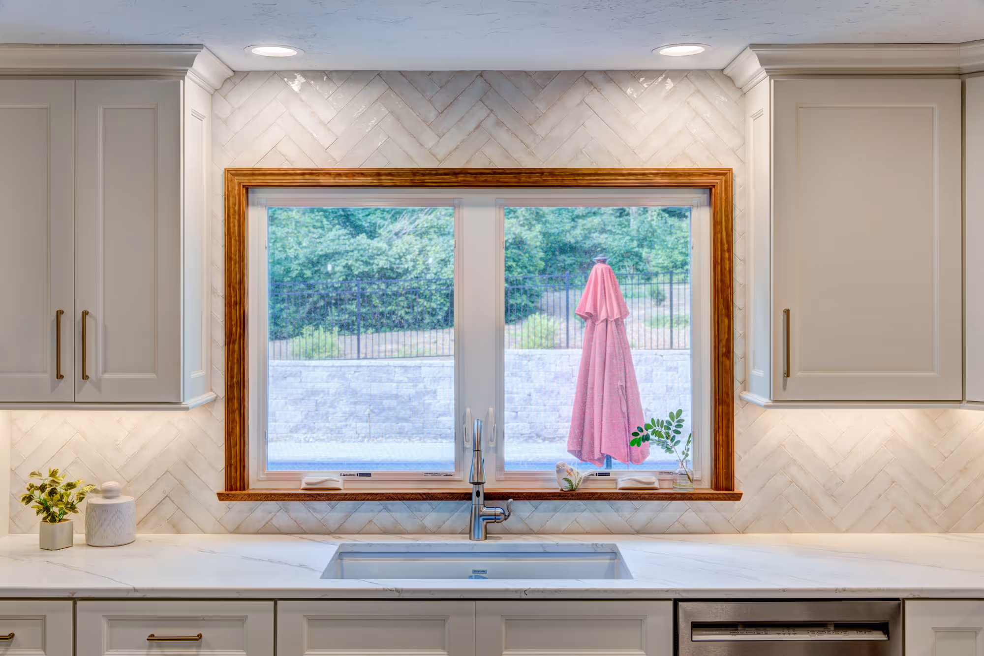 Contemporary kitchen with a herringbone backsplash and modern fixtures in Gettysburg, PA, featuring a sleek window view.