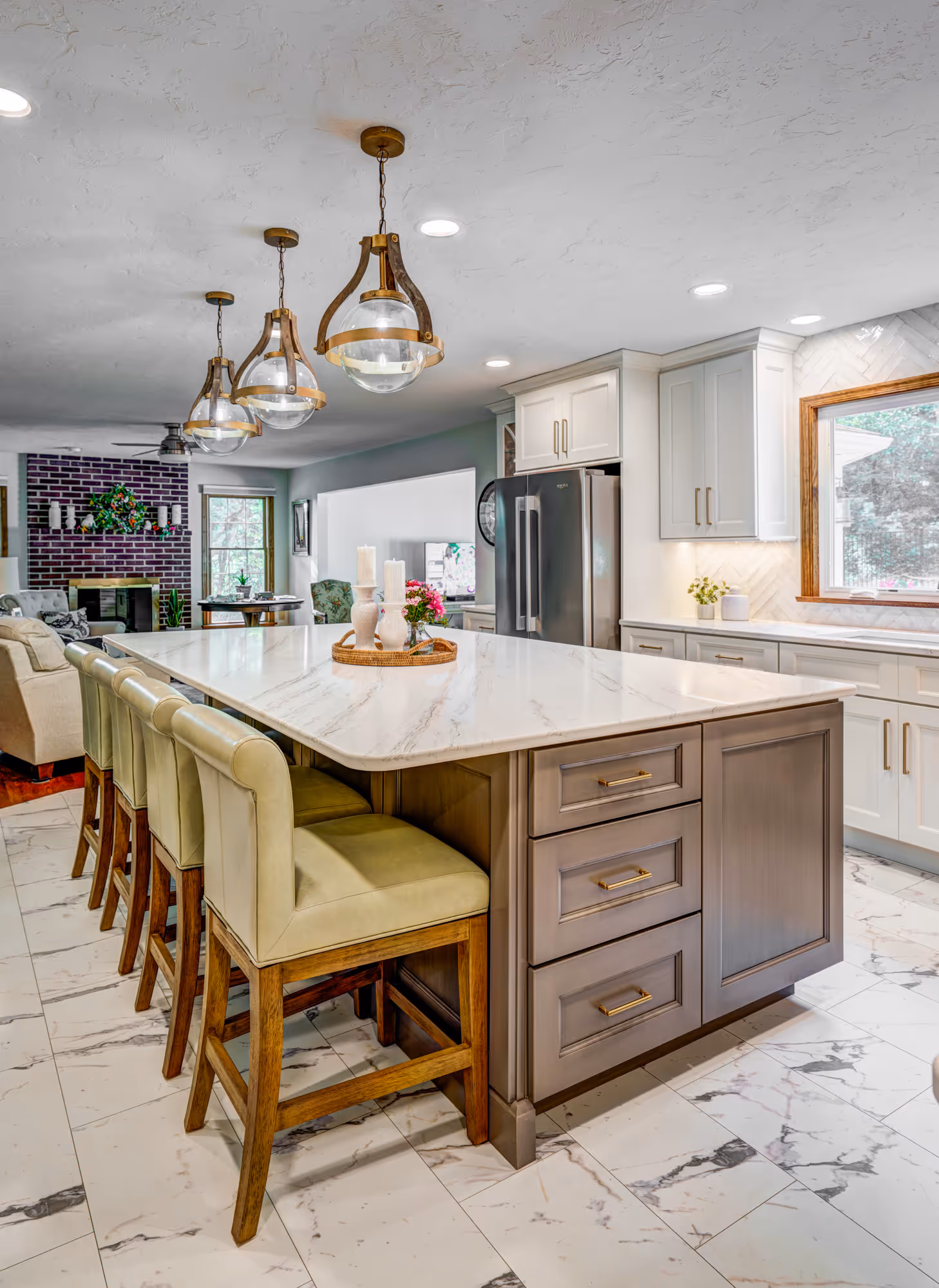 Modern kitchen in Gettysburg, PA featuring a marble island, gold hardware, and stylish pendant lights.