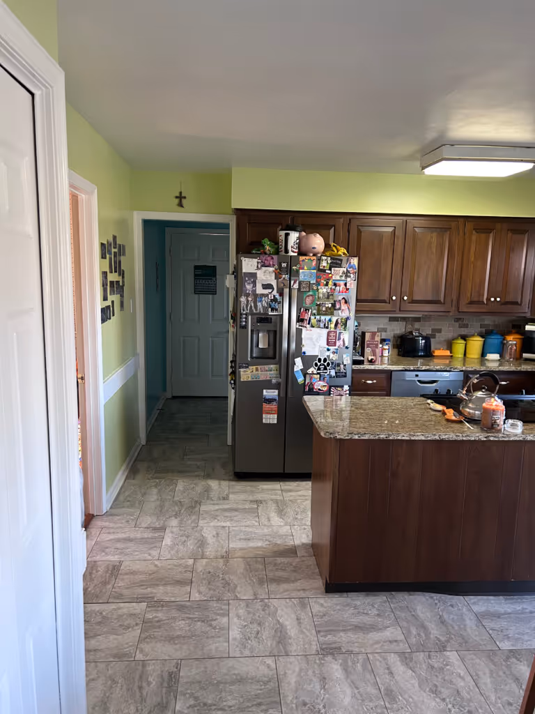 Modern kitchen in Mechanicsburg, PA with wood cabinets, gray tile flooring, and a spacious island.
