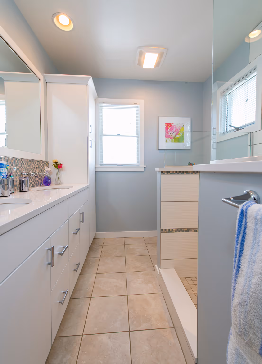Modern bathroom with white cabinetry, dual sinks, and glass shower featuring mosaic tile in Hummelstown, PA.