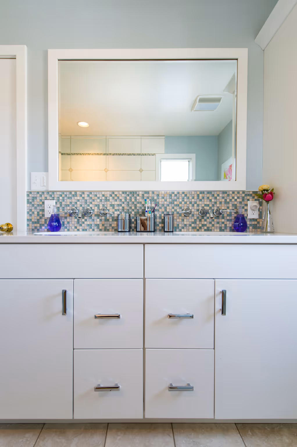 Modern bathroom vanity featuring white cabinets and colorful tiled backsplash in Hummelstown, PA.