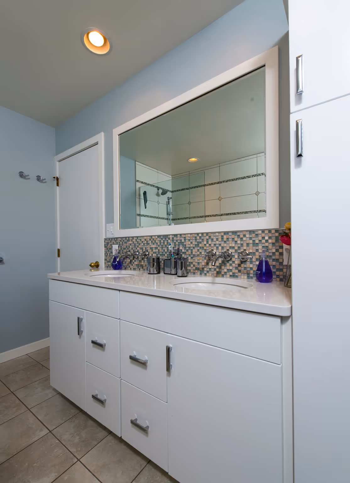 Modern bathroom with dual sinks, mosaic backsplash, and ample storage in Hummelstown, PA.