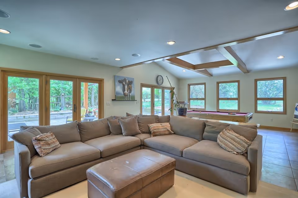 Modern living room with large sectional sofa, natural light, and green views in mechanicsburg, pa.