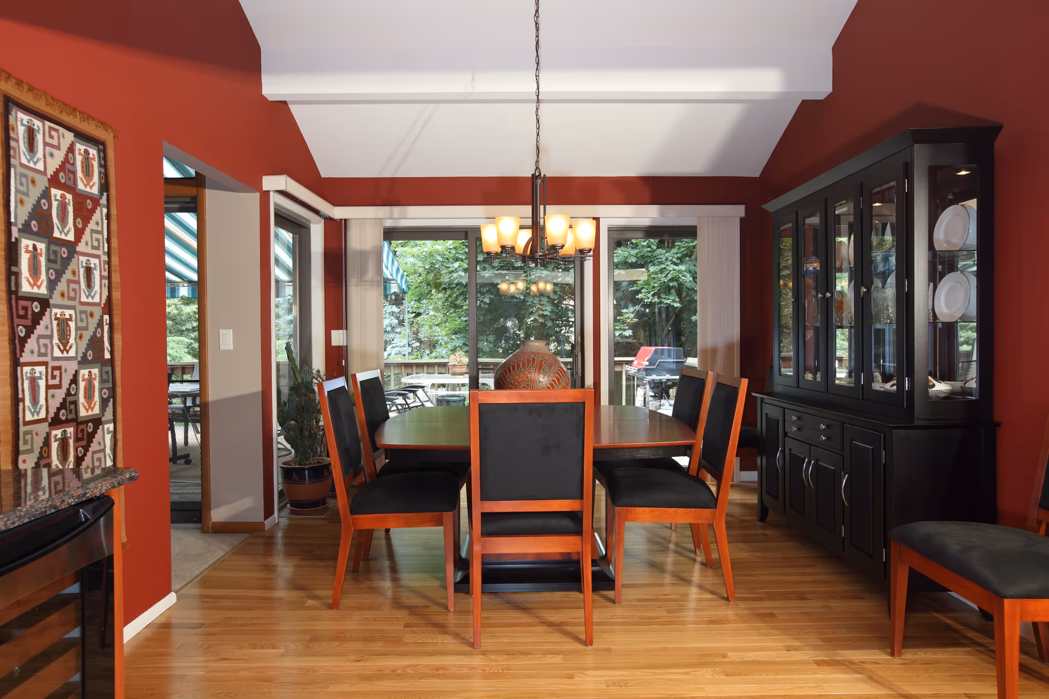 Contemporary dining room featuring a dark wood table, black upholstered chairs, and a stylish chandelier in Carlisle, PA.