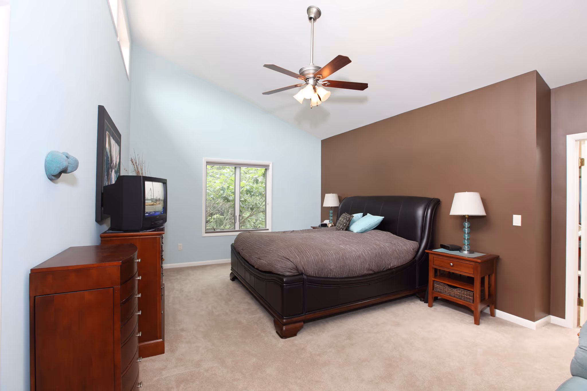 Cozy contemporary bedroom with a brown accent wall, plush bed, and elegant decor in Carlisle, PA.