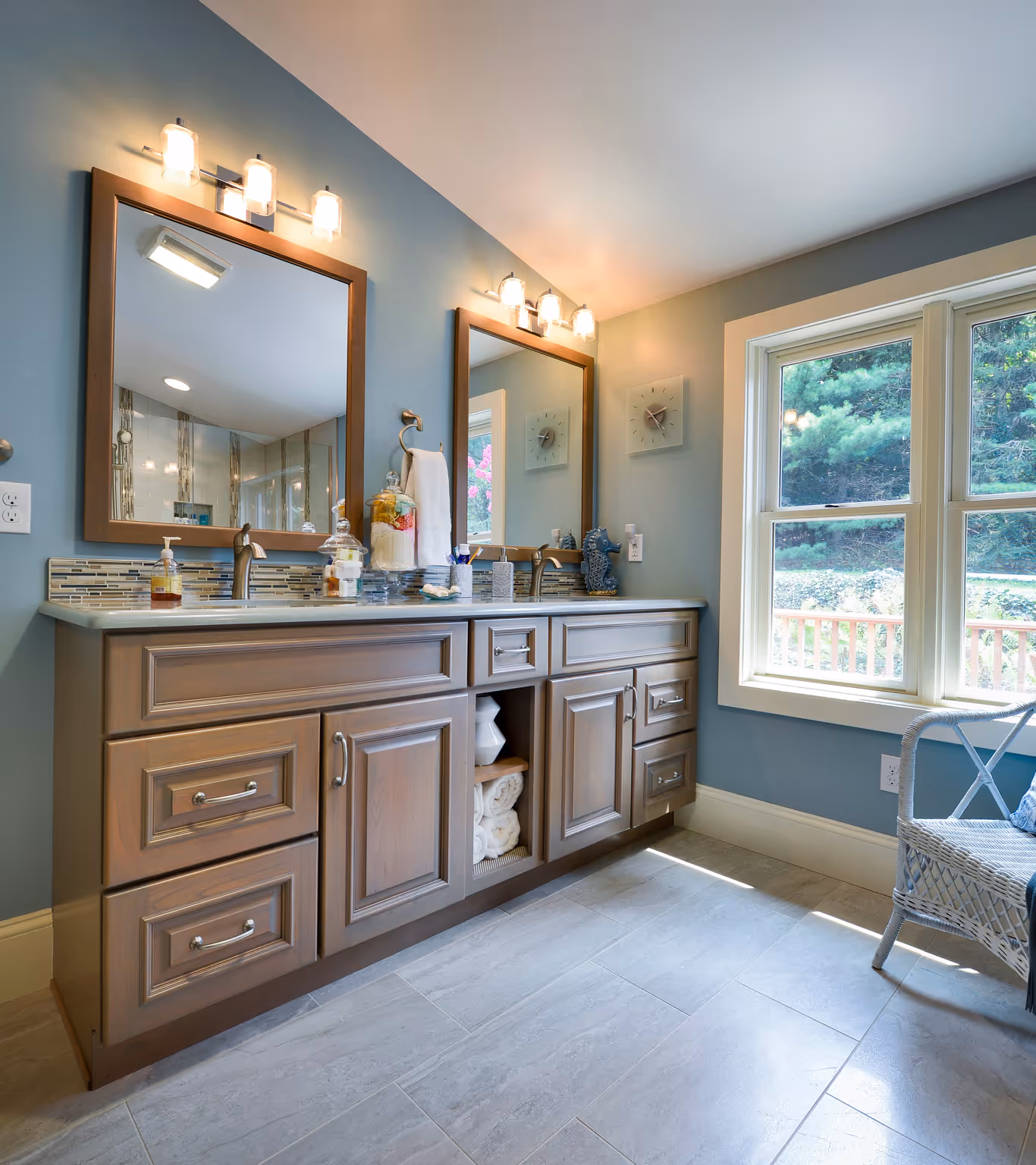 Transitional bathroom with dual mirrors, wooden cabinetry, and light gray tile flooring in Harrisburg, PA
