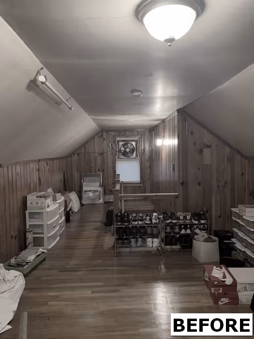 Attic room in New Cumberland, PA featuring wood paneling, storage solutions, and a variety of shoes.