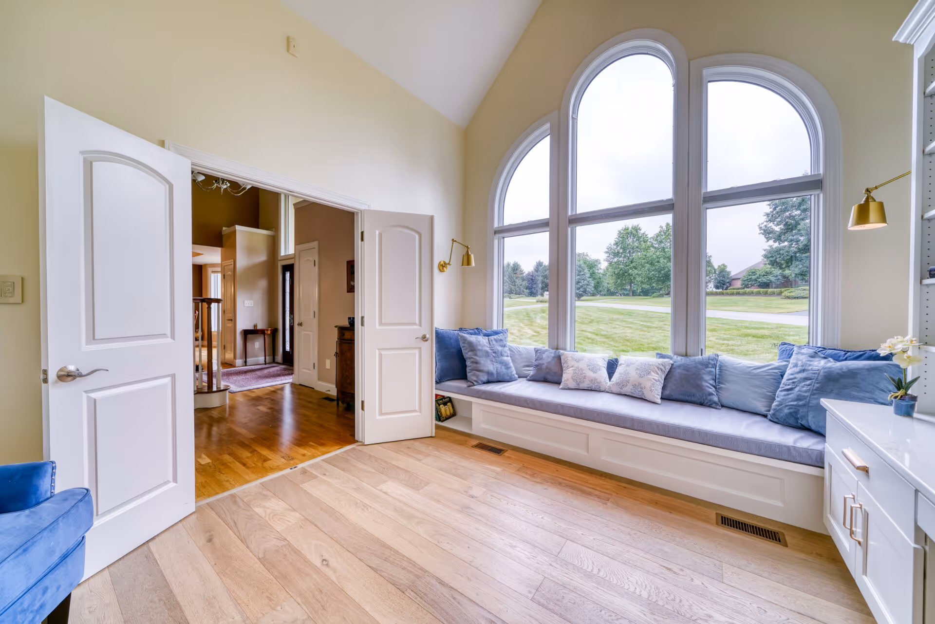 Modern office in Mechanicsburg, PA, featuring a cozy window seat with blue pillows and natural light from large arched windows.