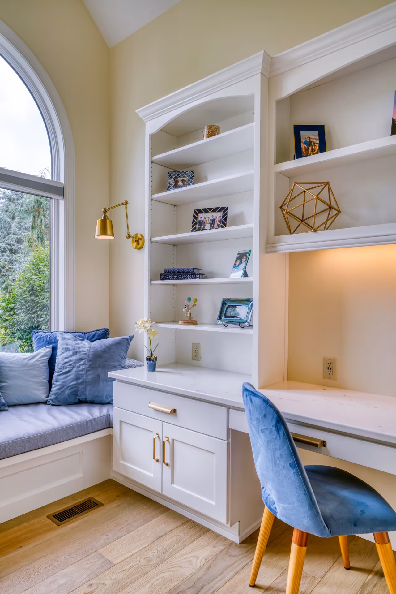 Modern office in Mechanicsburg, PA featuring white cabinetry, blue chair, and stylish decor with natural light.