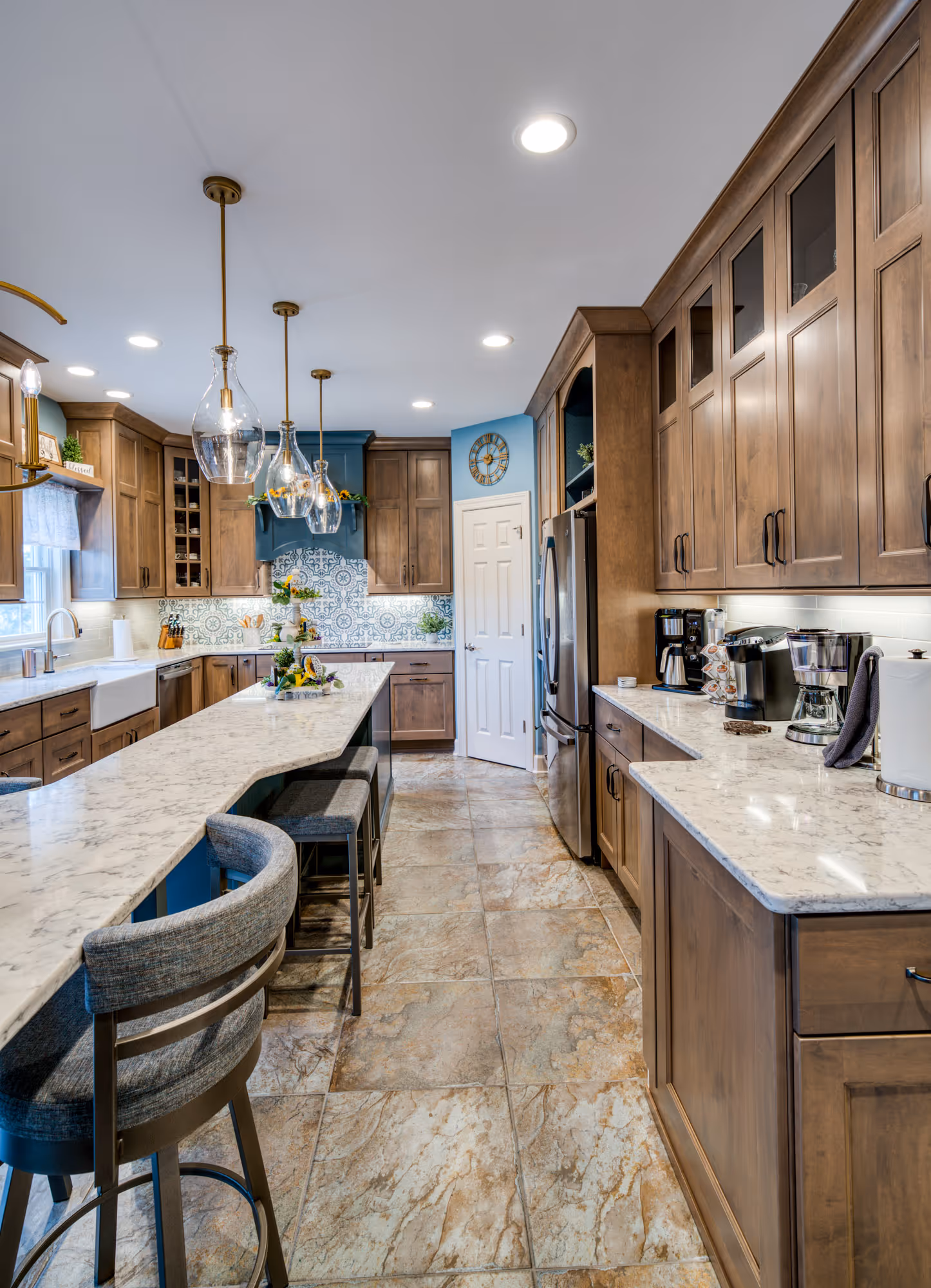 Modern kitchen with marble countertops, wooden cabinets, and blue backsplash in Mechanicsburg, PA