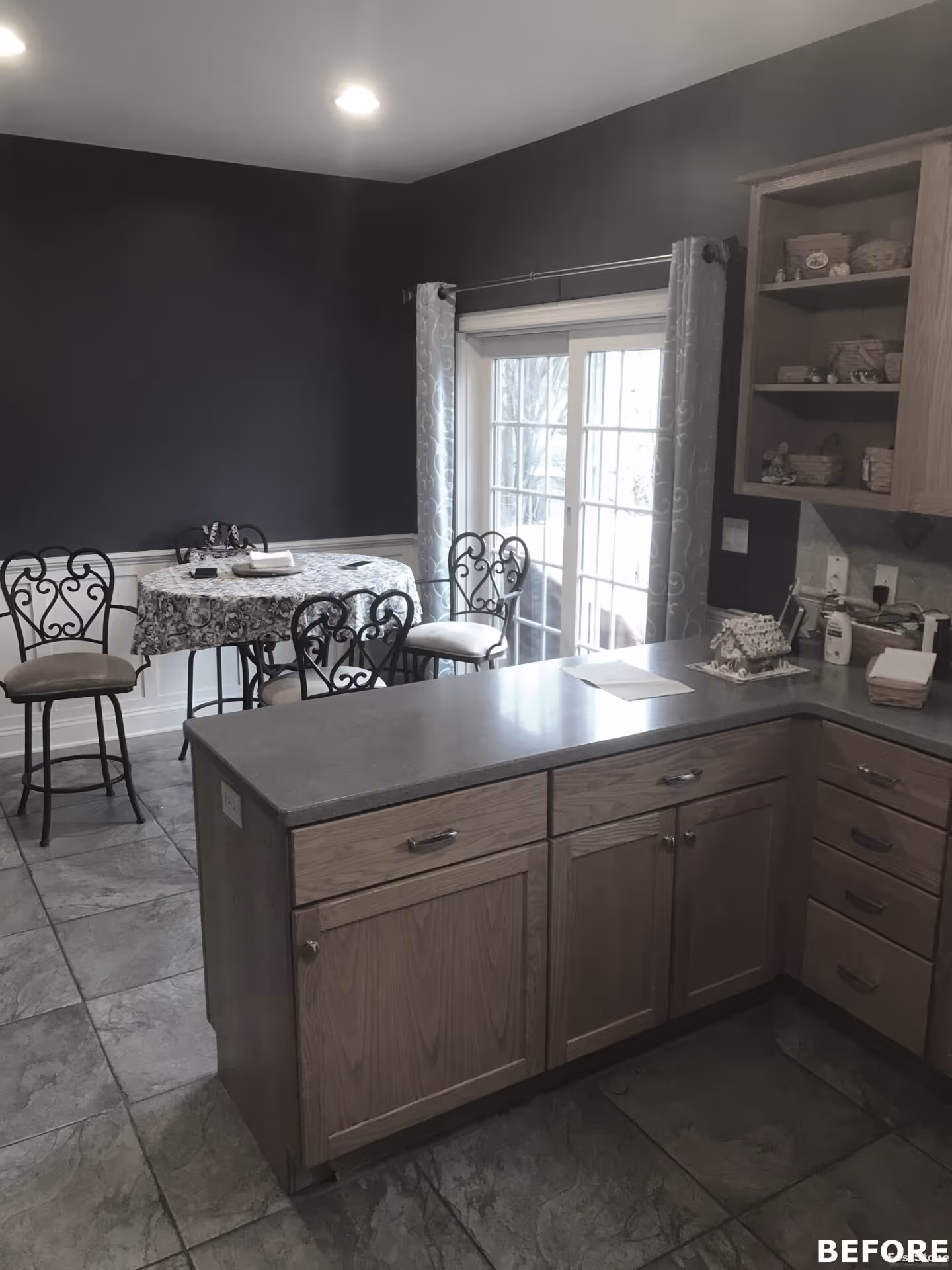 Modern kitchen in Mechanicsburg, PA featuring a gray countertop and dark accent wall with dining area