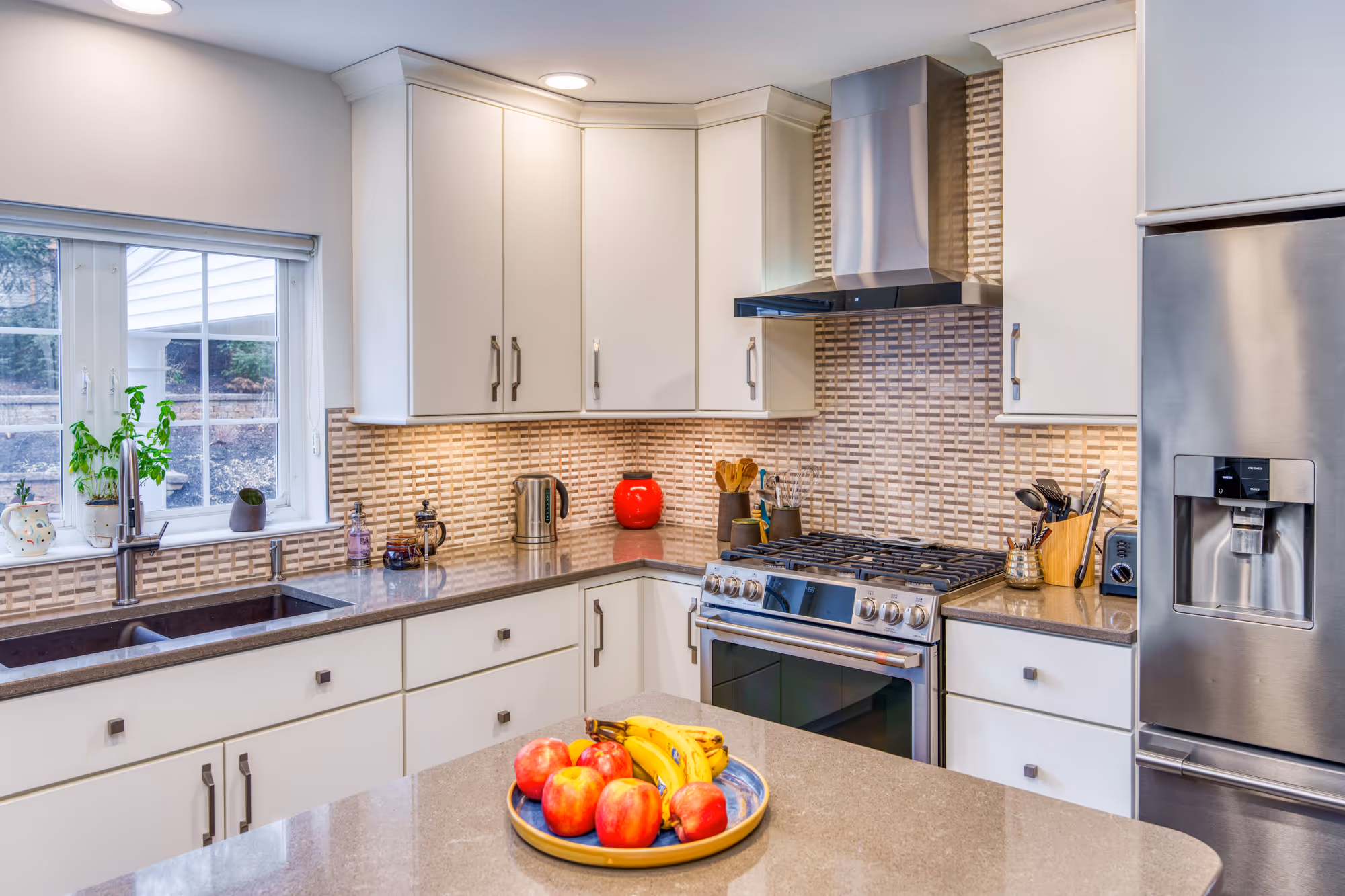 Contemporary kitchen in Hummelstown, PA featuring white cabinetry, brown countertop, and decorative backsplash.