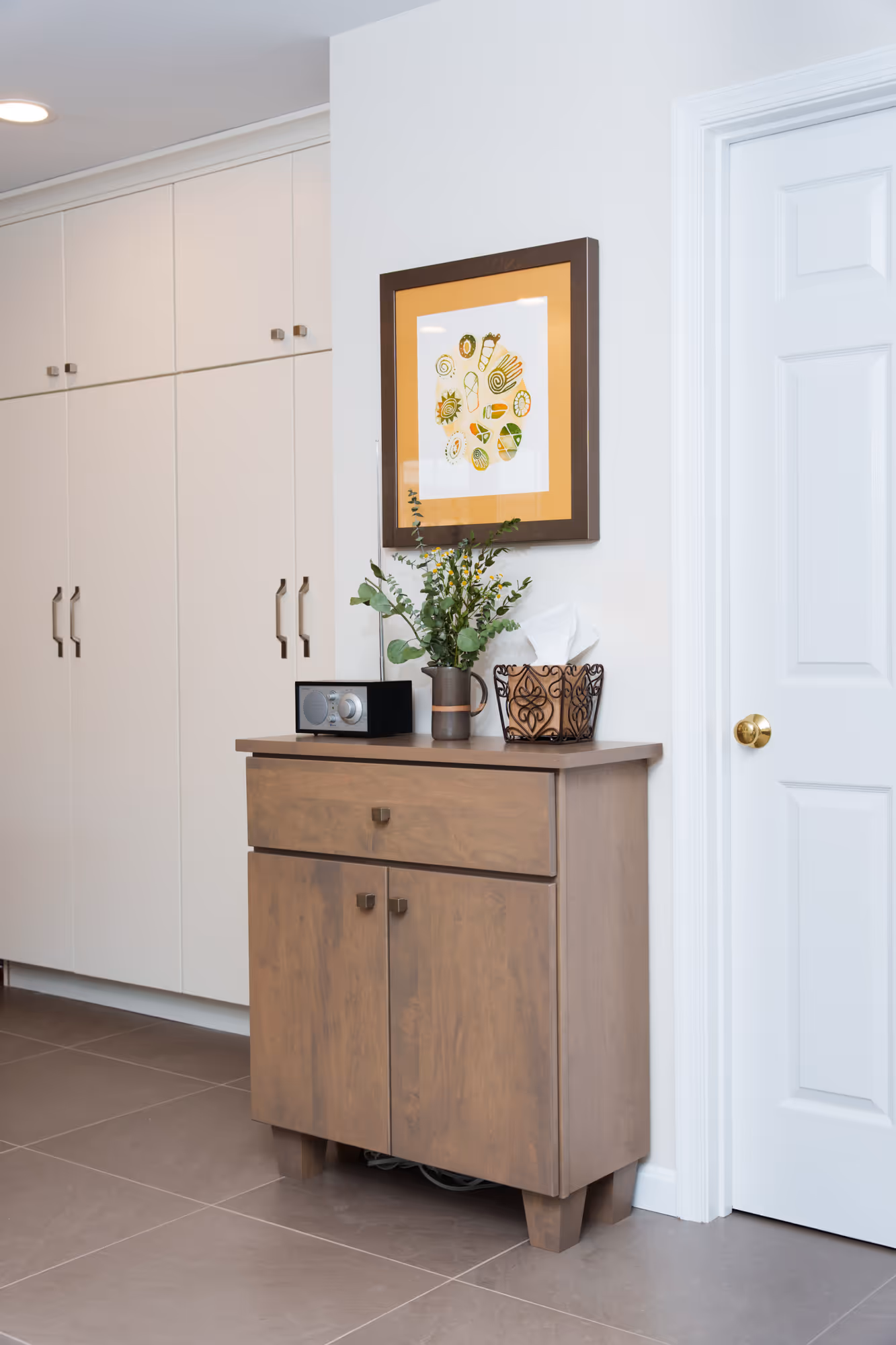 Modern kitchen storage cabinet in Hummelstown, PA with art and plants.