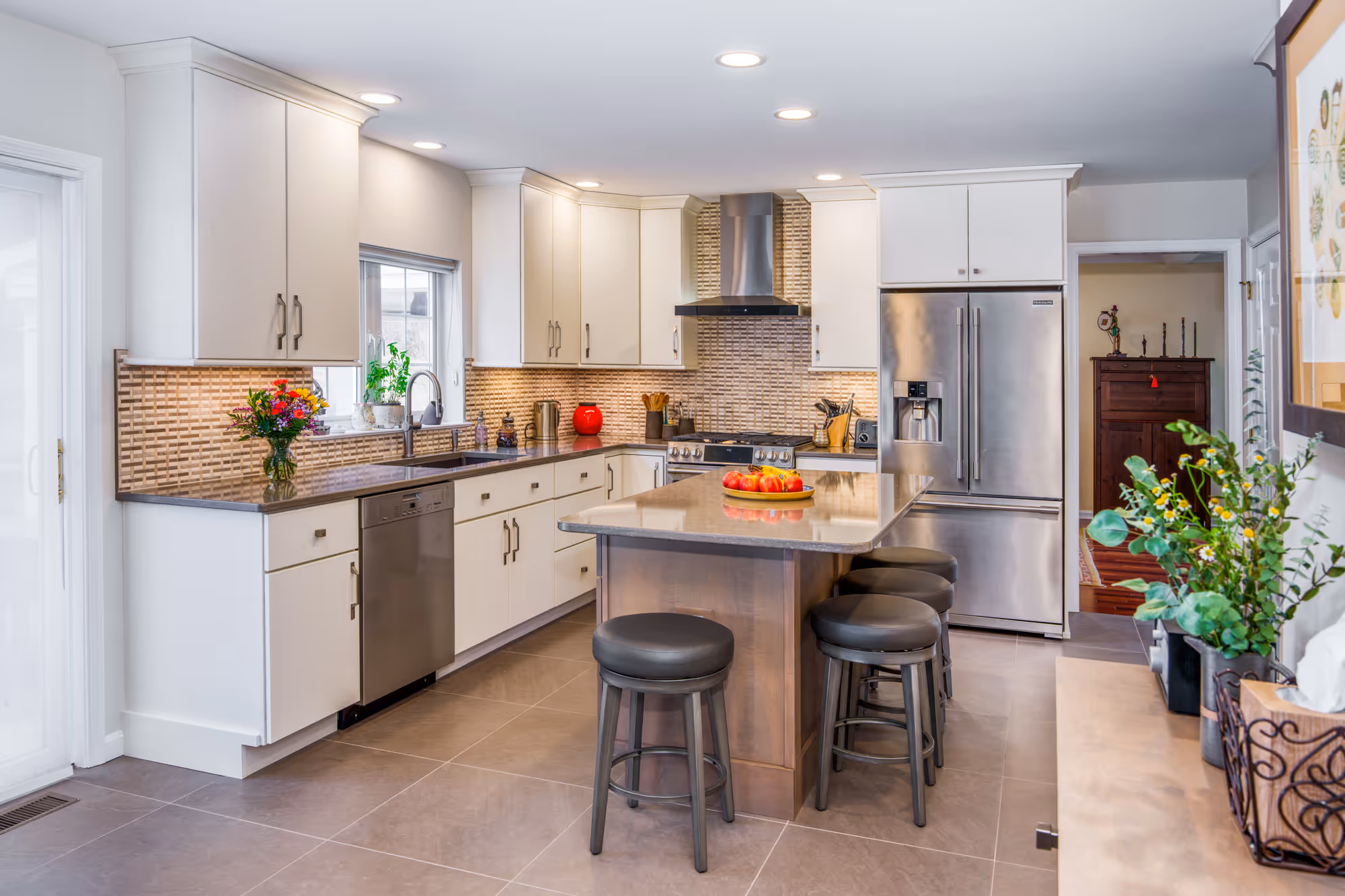 Modern kitchen in Hummelstown, PA featuring sleek cabinetry, a central island with seating, and elegant tile backsplash.