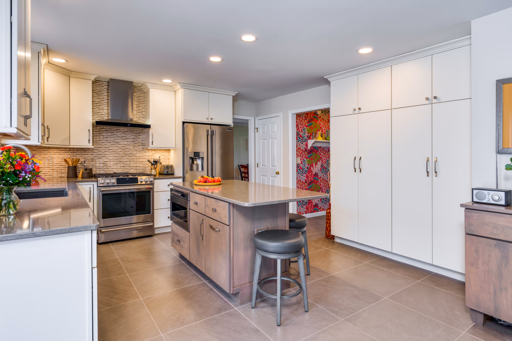 Modern kitchen in hummelstown, pa featuring white cabinetry, gray countertops, and a bold floral accent wall.