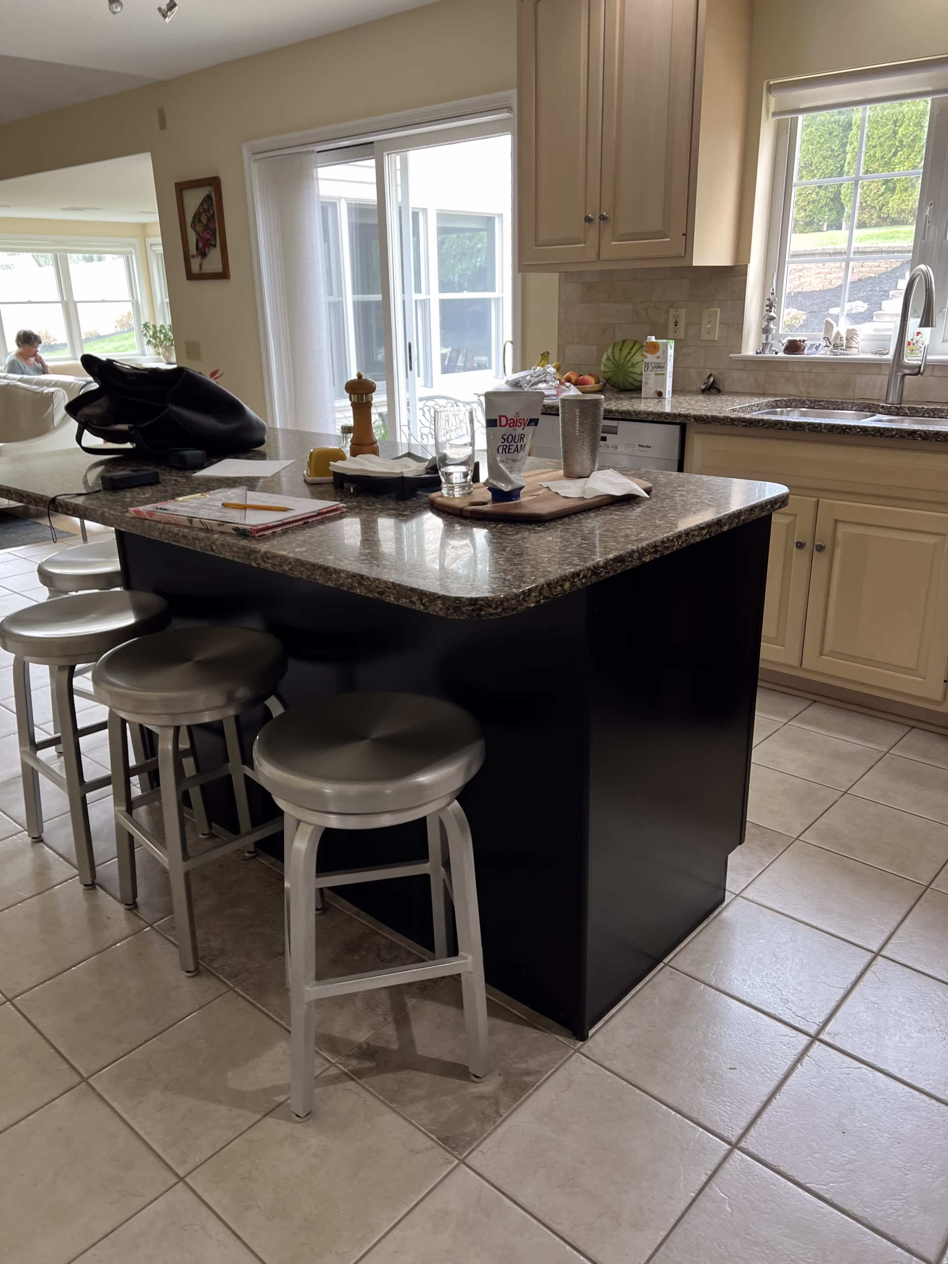 Modern kitchen with granite countertop, stainless steel stools, and natural light in hummelstown, pa
