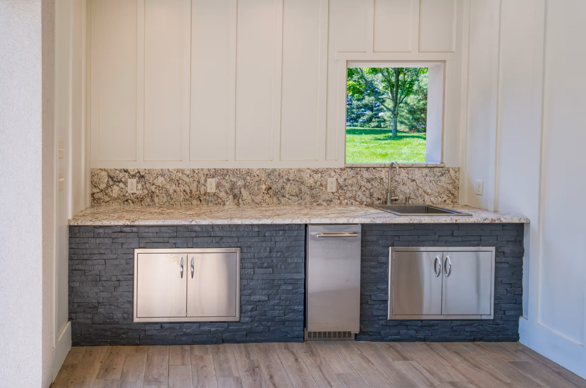 Modern outdoor kitchen with granite countertop, stainless steel appliances, and stone cabinetry in Mechanicsburg, PA.