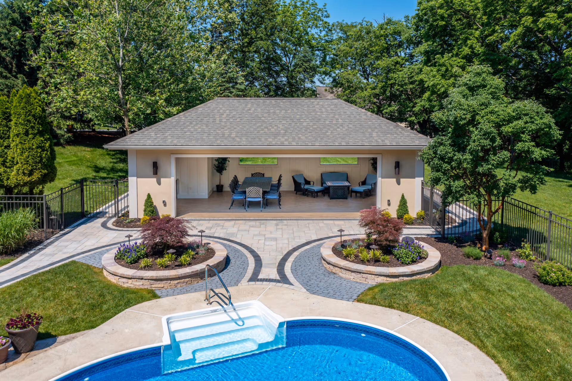 Modern outdoor poolhouse in Mechanicsburg, PA, featuring comfortable seating and landscaped garden.