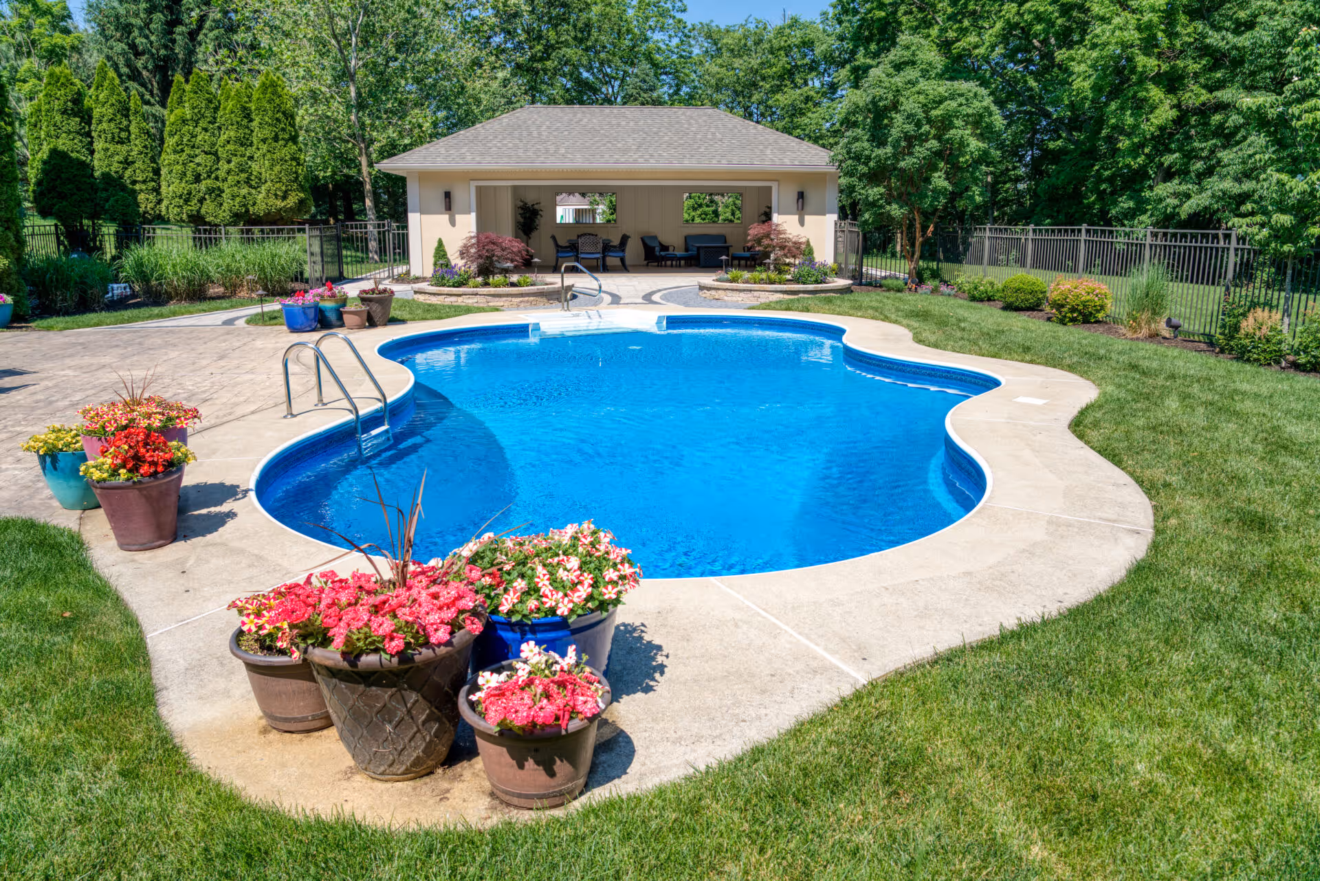 Outdoor pool area featuring colorful flower pots and a gazebo in Mechanicsburg, PA