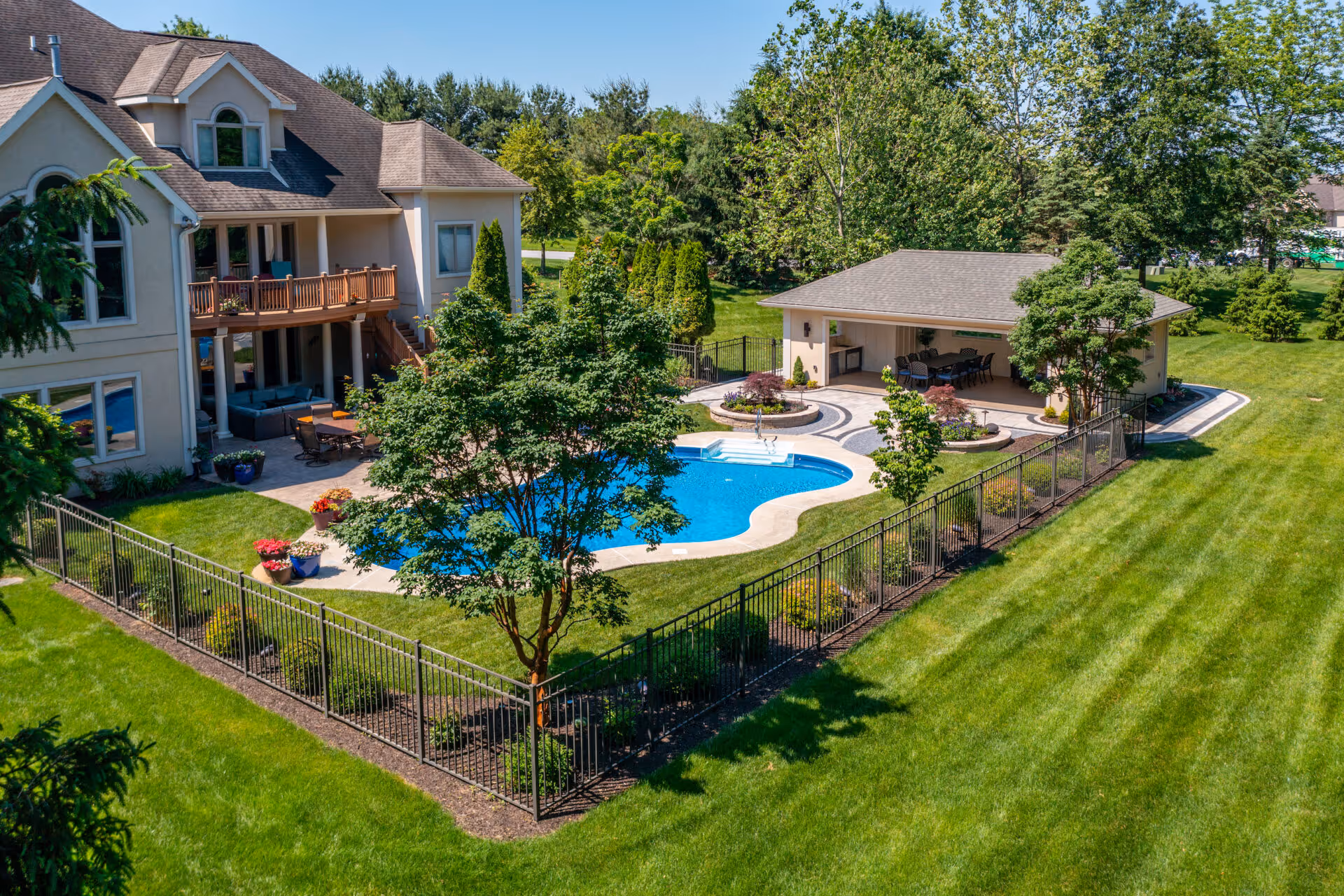 Modern outdoor pool area with landscaped garden and patio in mechanicsburg, pa