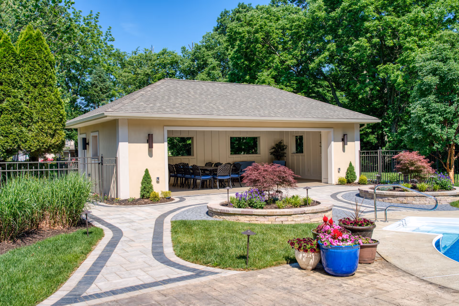 Stylish pool house in Mechanicsburg, PA featuring outdoor dining, landscaping, and a modern design.