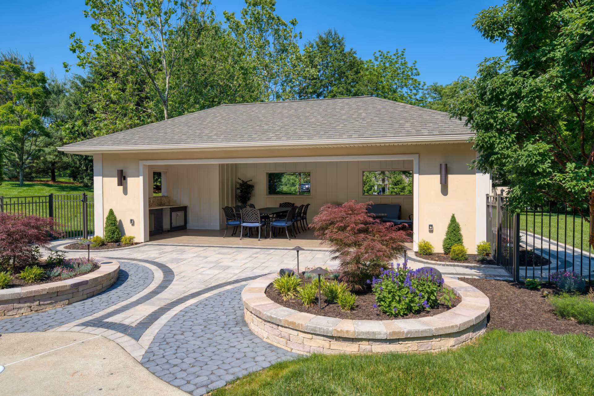 Contemporary outdoor pool house in Mechanicsburg, PA with seating area and lush landscaping.