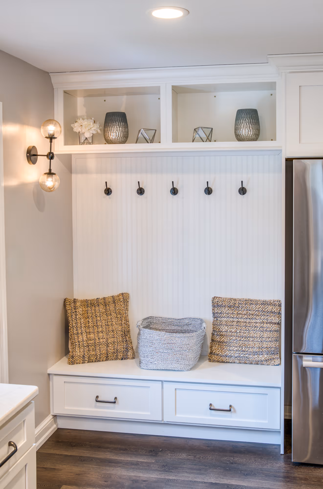 Stylish coat tree area featuring white cabinetry, woven pillows, and decorative accents in a kitchen remodel in marysville, pa.