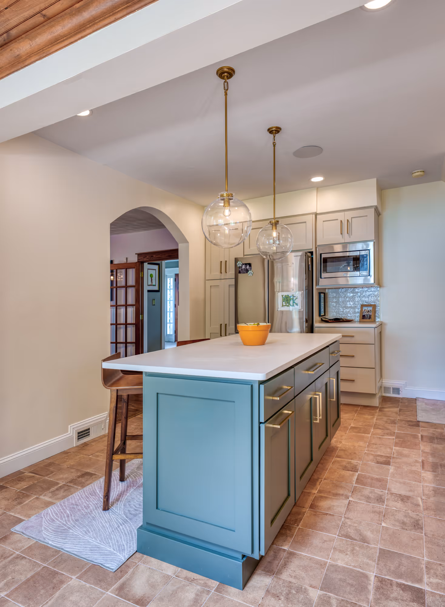 Modern kitchen in Harrisburg, PA featuring turquoise island, glass globe pendant lights, and cream cabinetry.