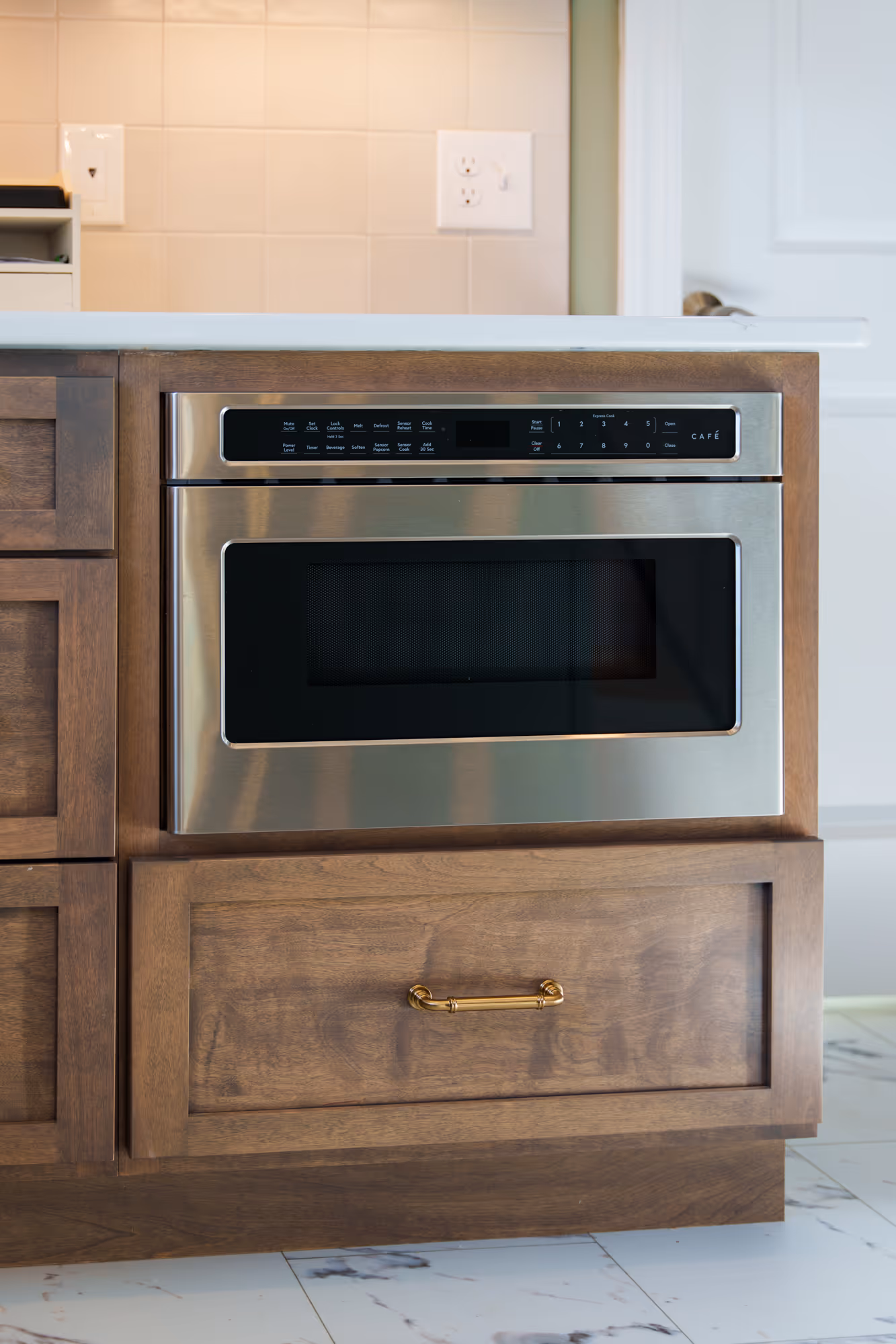 Modern kitchen in Harrisburg, PA featuring a microwave drawer with sleek stainless steel finish and warm wood cabinetry.