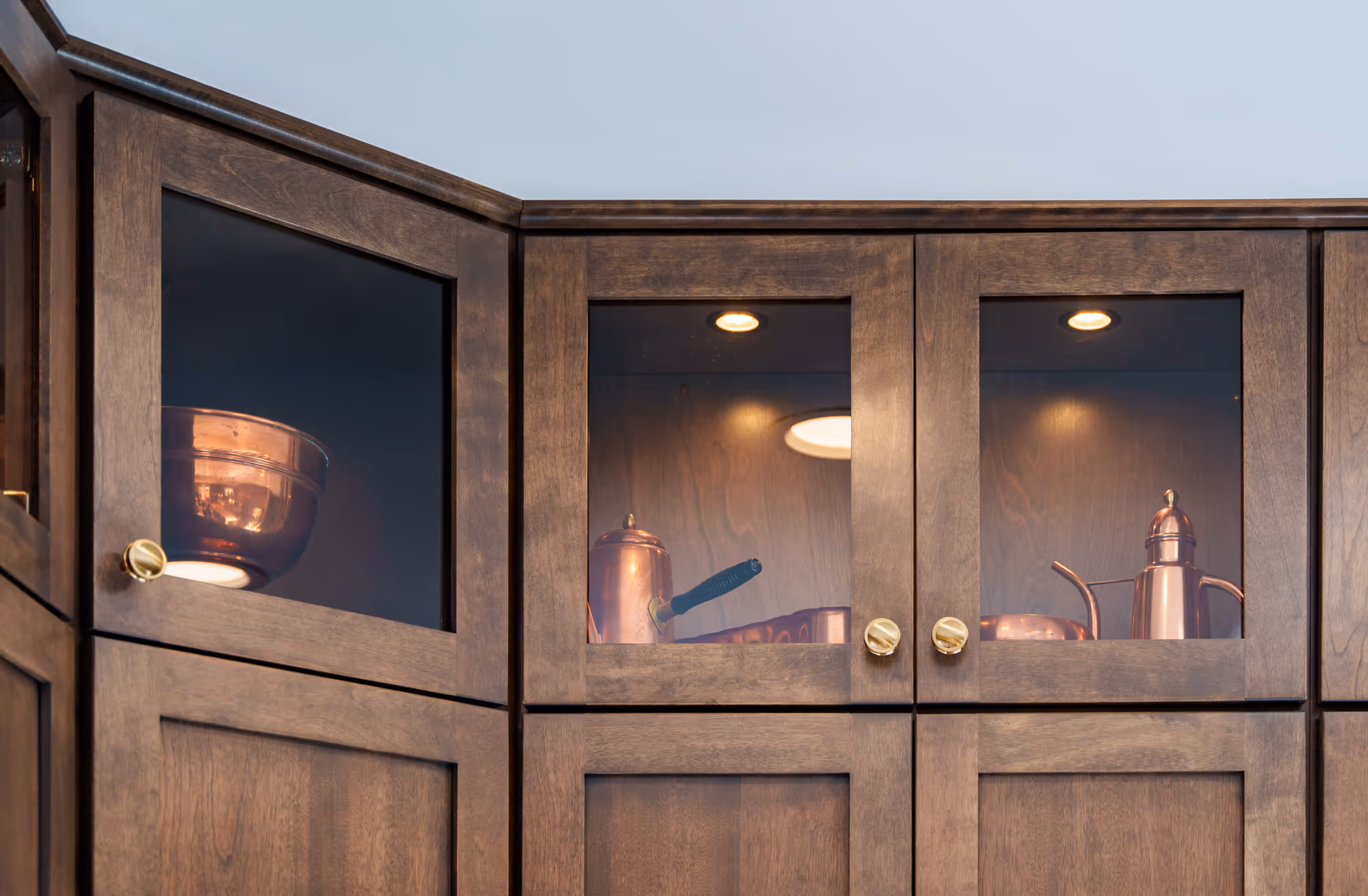 Contemporary kitchen display featuring glass cabinets with copper cookware in Harrisburg, PA.