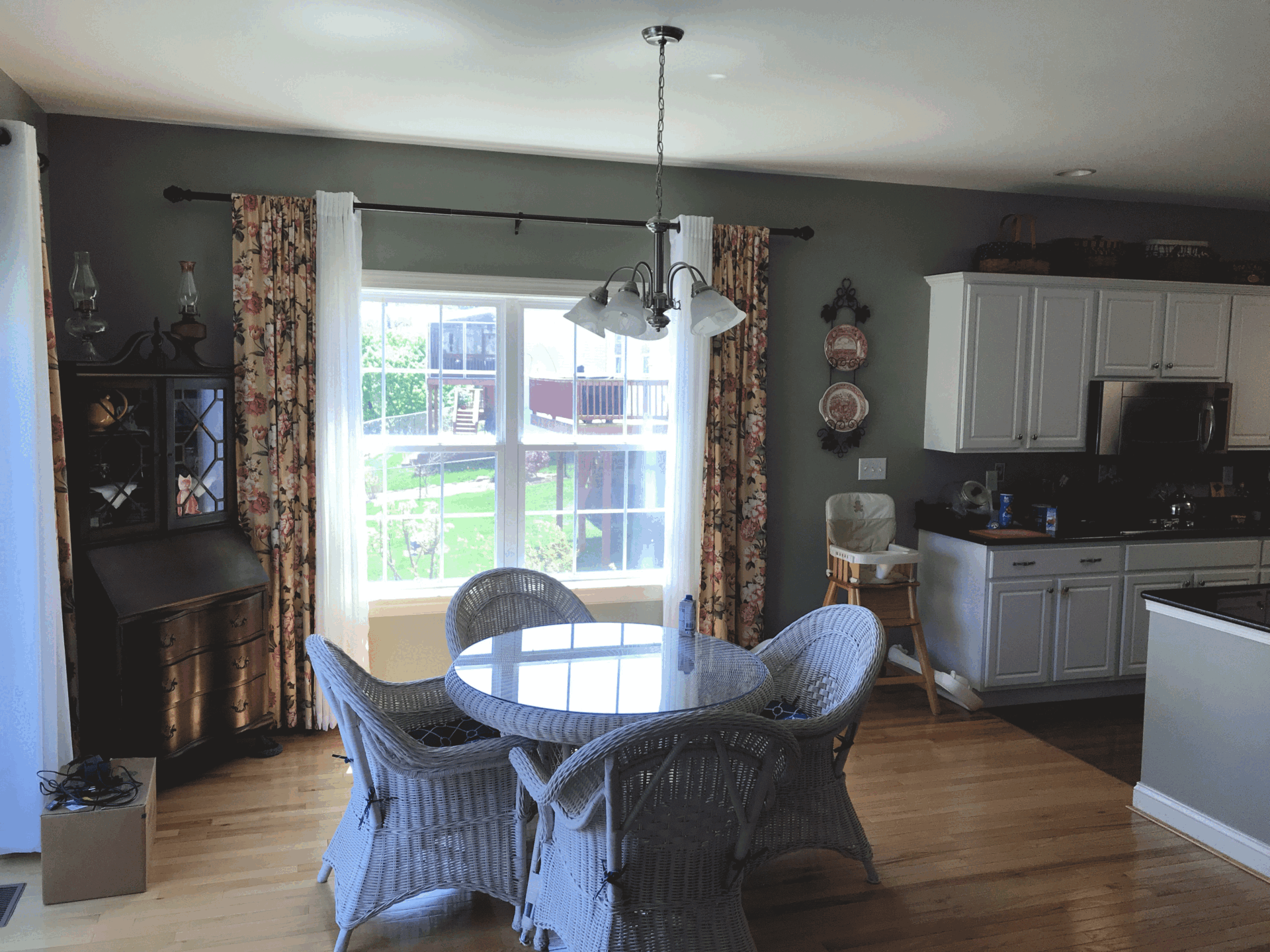 Cozy dining area with a round table and wicker chairs featuring floral curtains, set in a Harrisburg, PA home