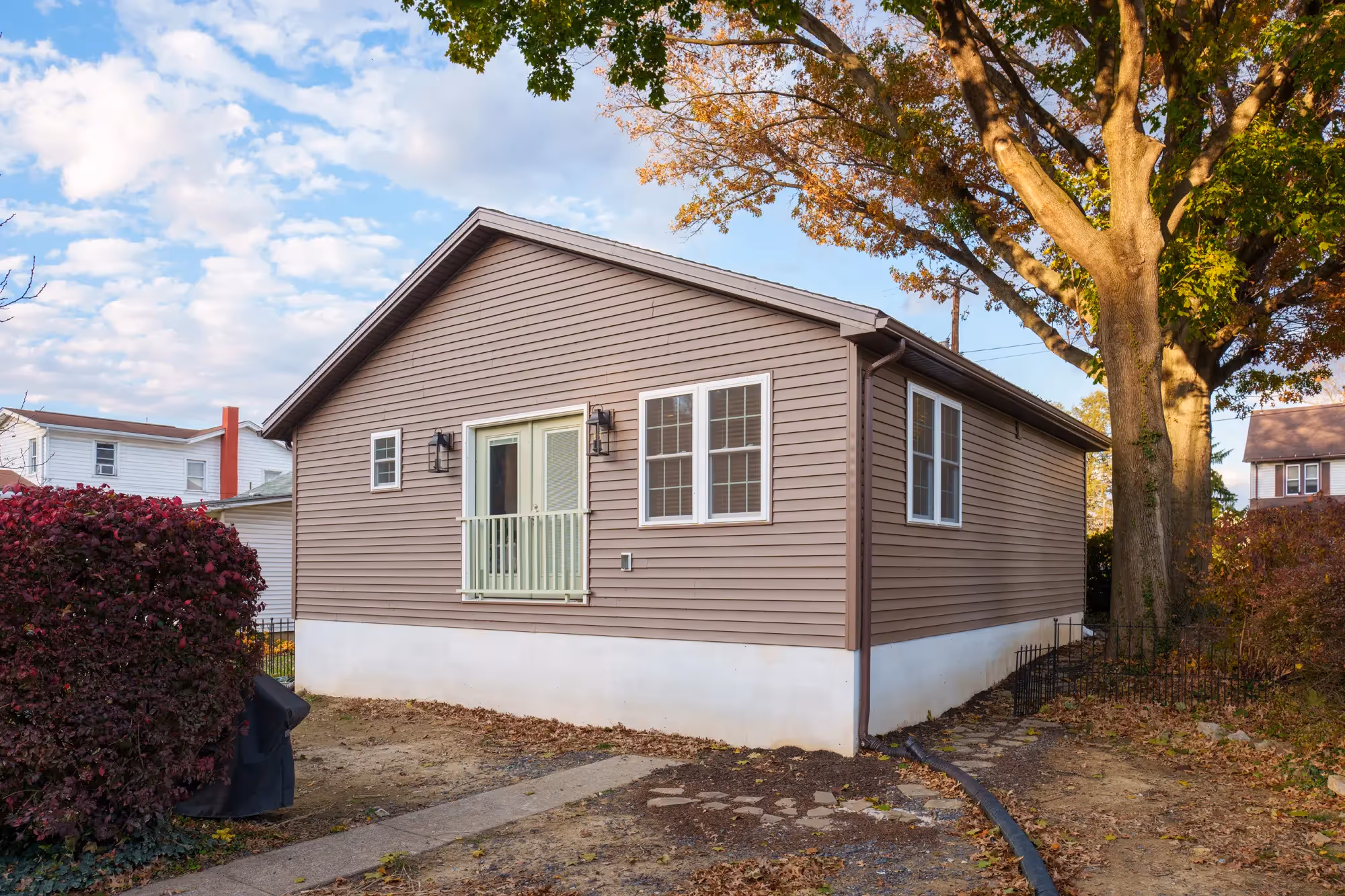 Exterior of the house with a freshly remodeled look and autumn setting