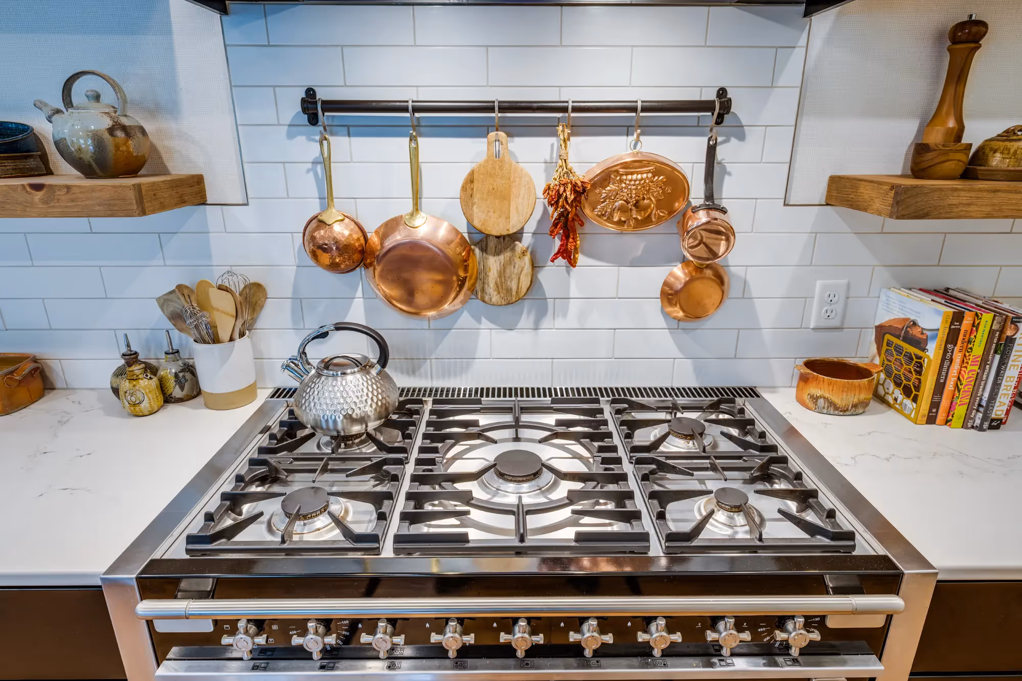 Stylish kitchen with gas stove, range hood, and polished countertops.