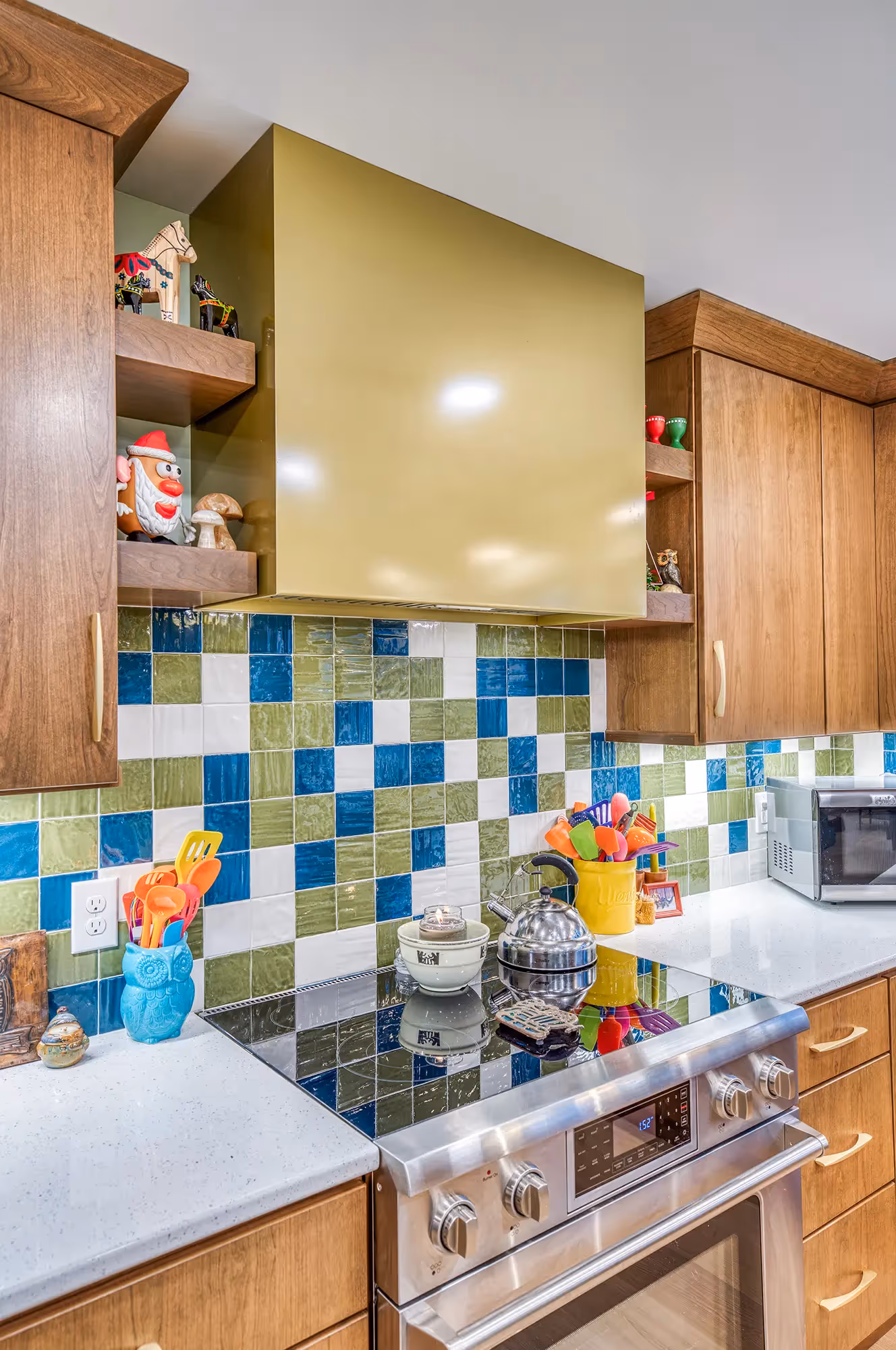 Kitchen with green and blue tiles, wooden cabinetry