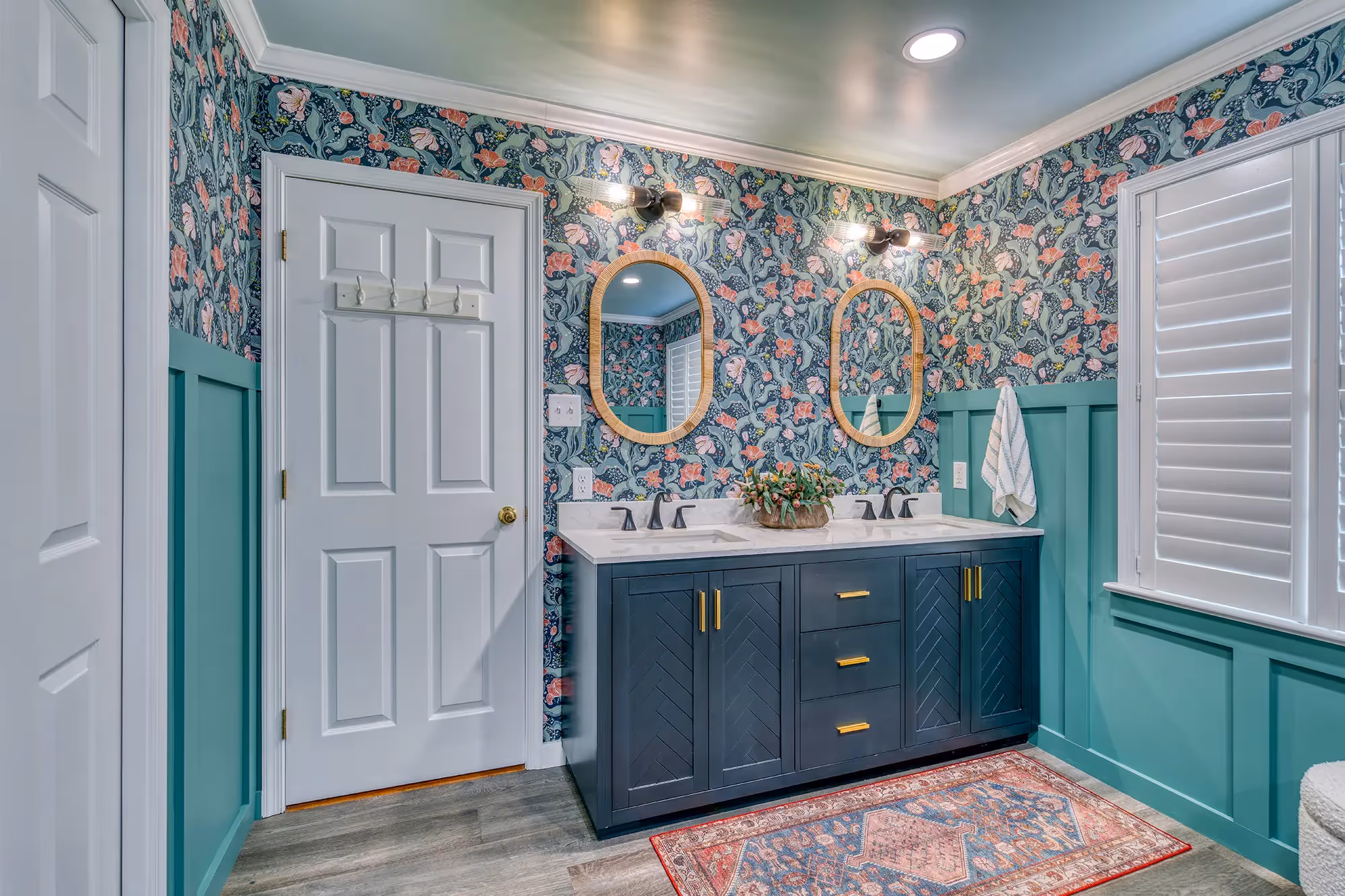 Vibrant bathroom with teal walls, floral wallpaper