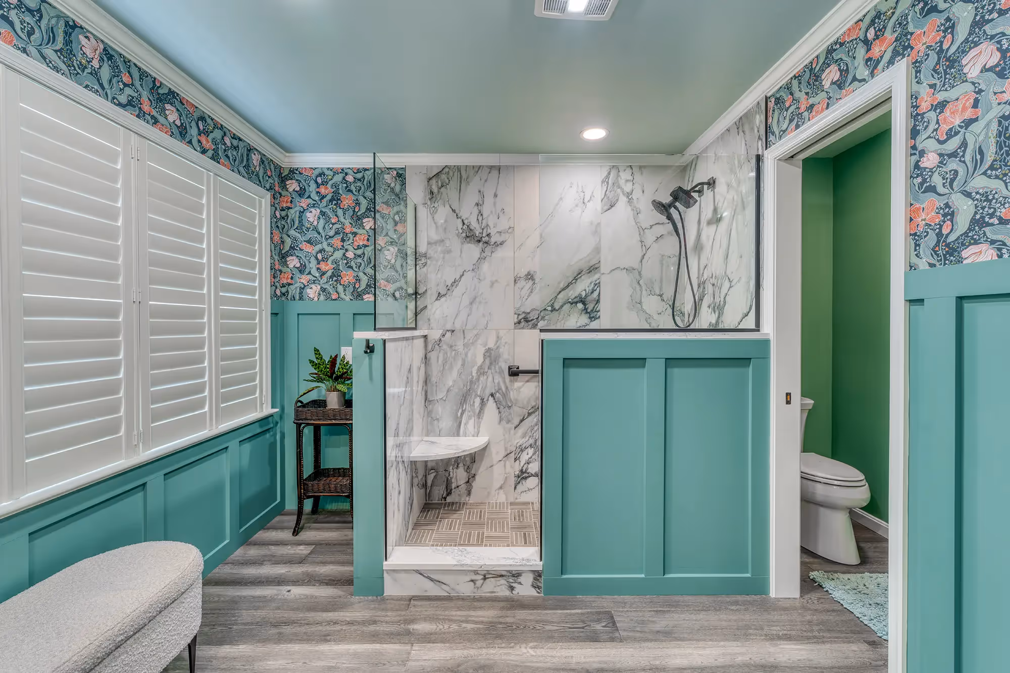 Vibrant bathroom with teal walls, floral wallpaper