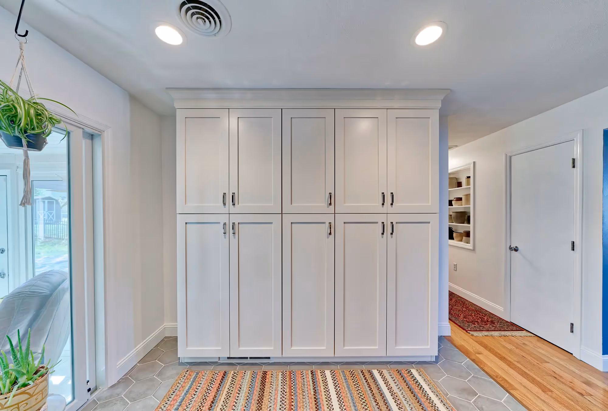 Kitchen area with white cabinetry, modern fixtures