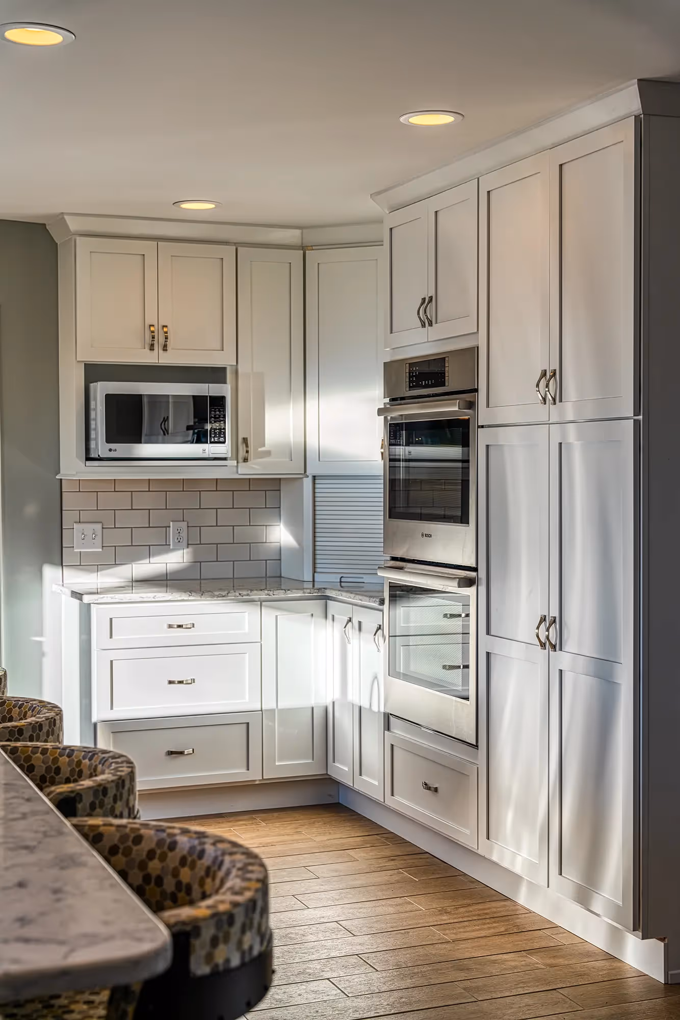 View of a long kitchen with white cabinets