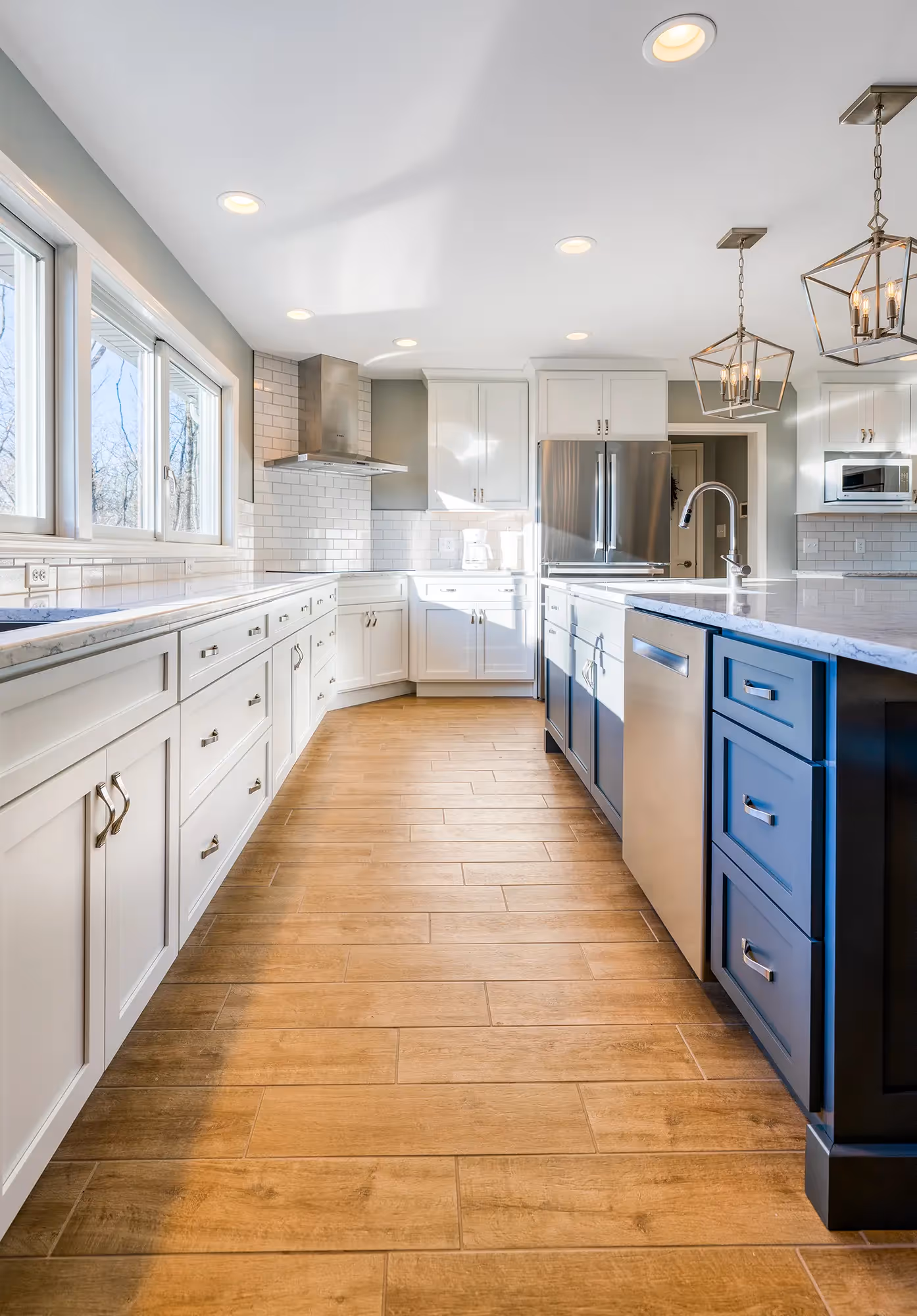 View of a long kitchen with white cabinets