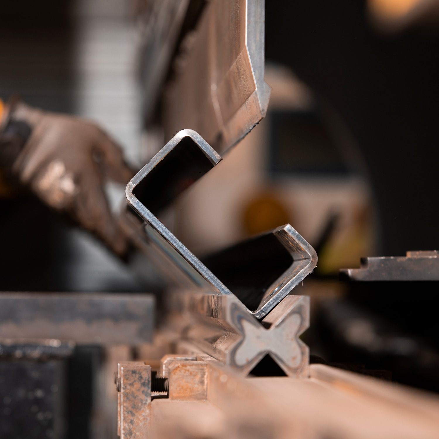 Close-up of a metal sheet being bent precisely by an advanced CNC folding machine.