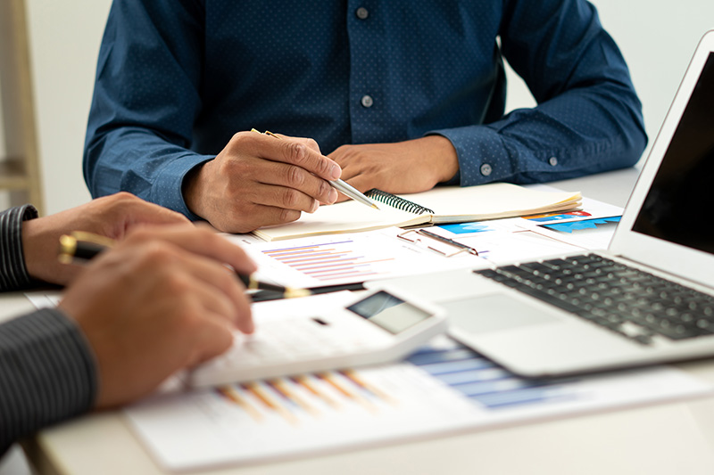 People reviewing documents on a desktop 
