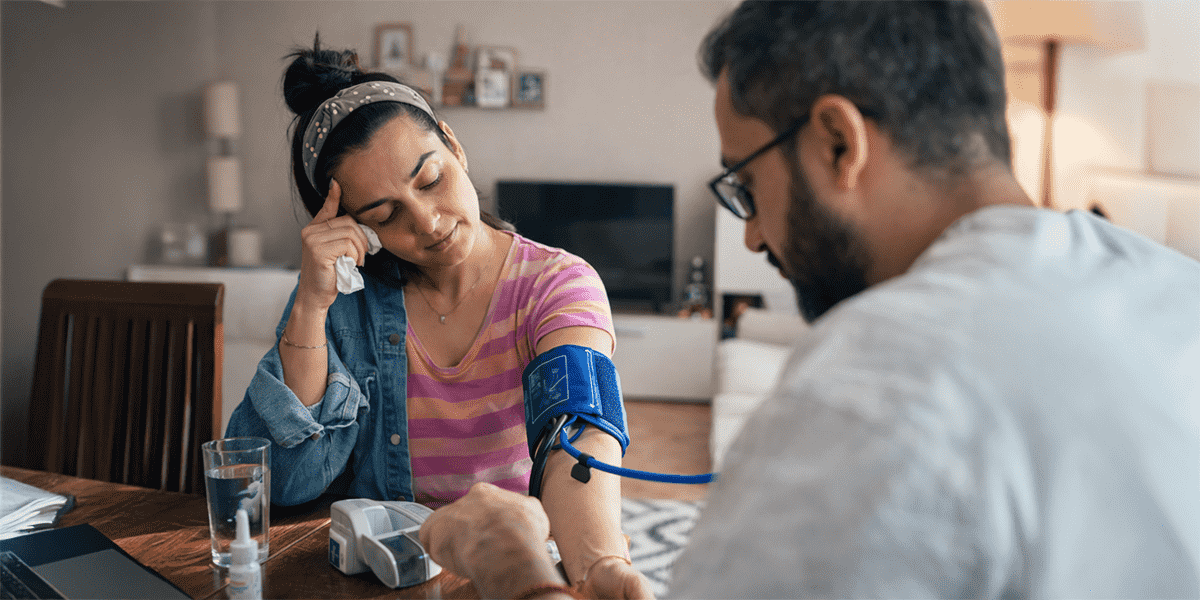 Woman having blood pressure checked while highlighting the concept of hidden heart disease risk despite normal medical tests