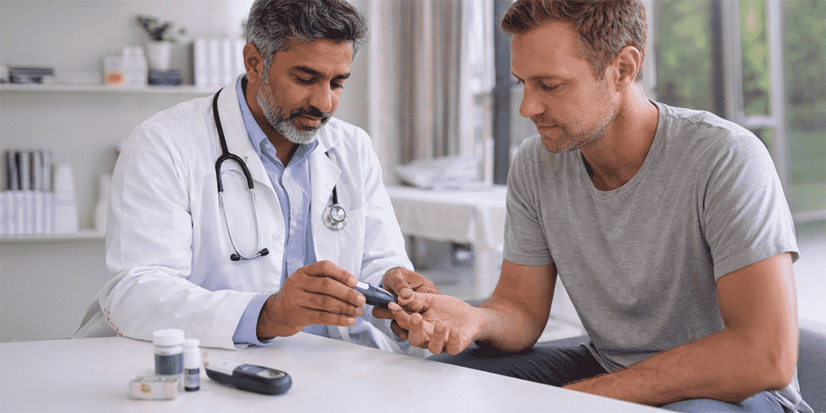 Doctor checking patient blood glucose with glucometer during diabetes consultation