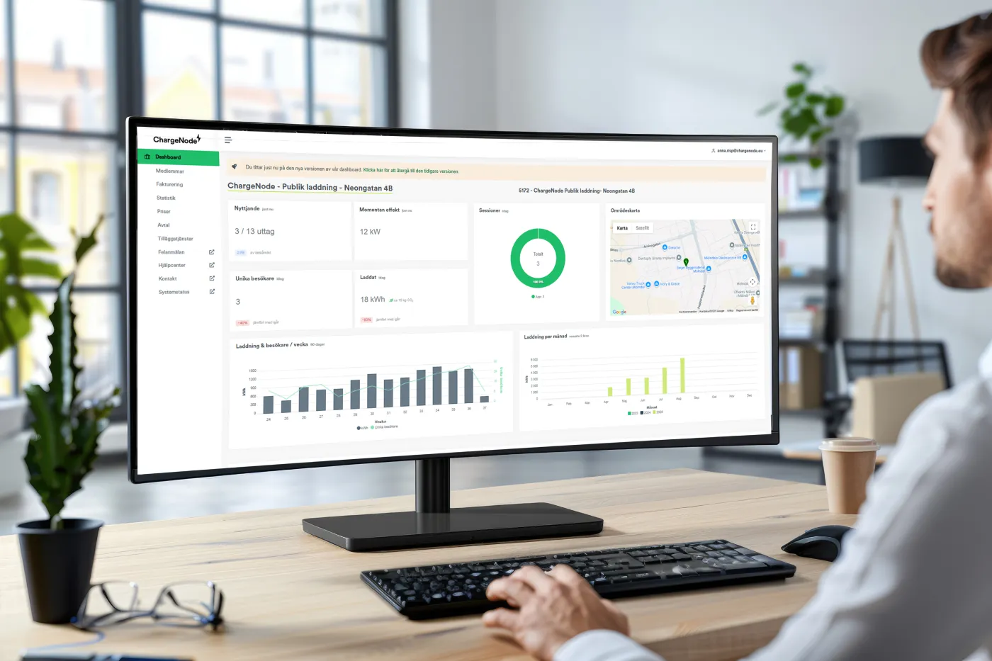 Person som använder en dator med ChargeNode plattformens dashboard som visar laddningsstatistik och kartvy.
