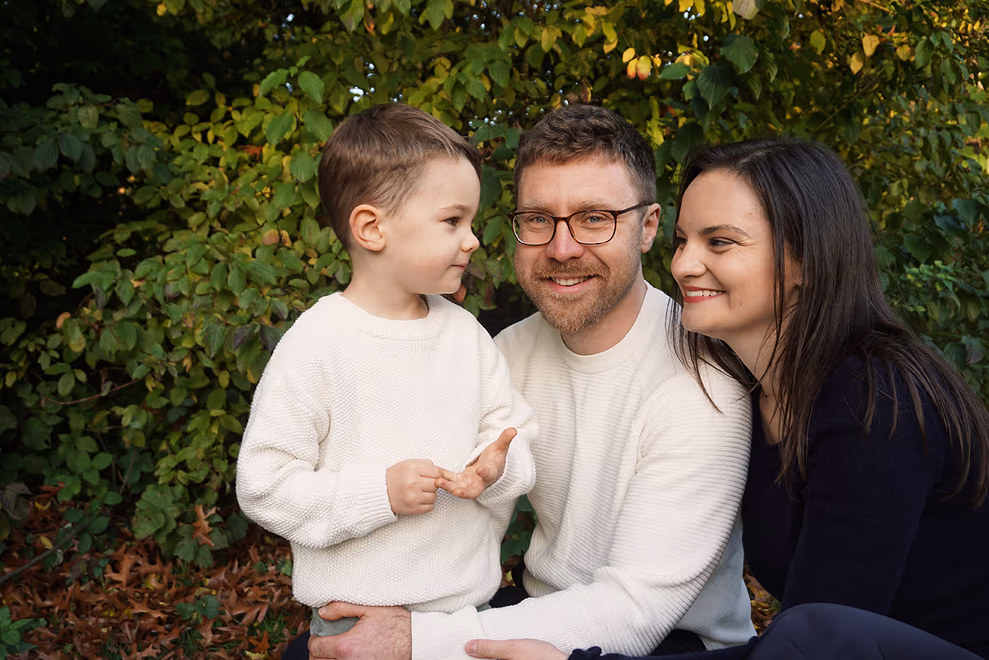 Junge Familie. In der Mitte der Papa, links von ihm sein Sohn, rechts von ihm seine Frau.