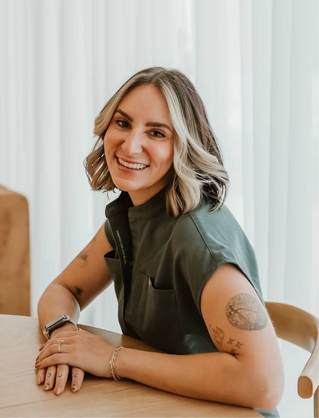 A woman sitting at a table with a smile on her face.